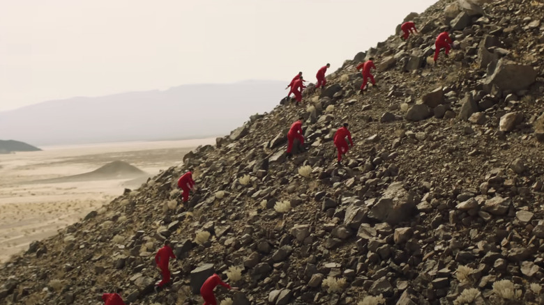 Men in red run up hill