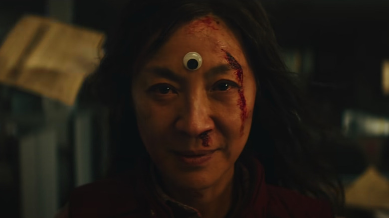 Evelyn (Michelle Yeoh) wearing the googly eye in Everything Everywhere All at Once