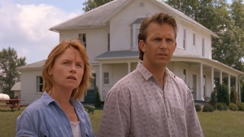 Kevin Costner and Amy Madigan staring into the field