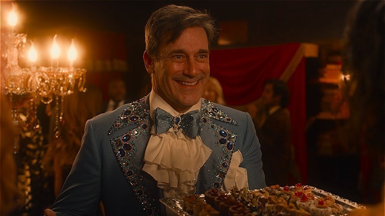 Gabriel in sequin blue suit holding food tray