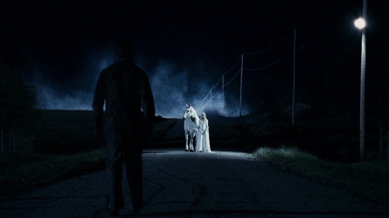 Michael walking toward white horse