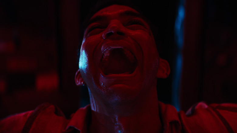 Colin screaming bathed in red light