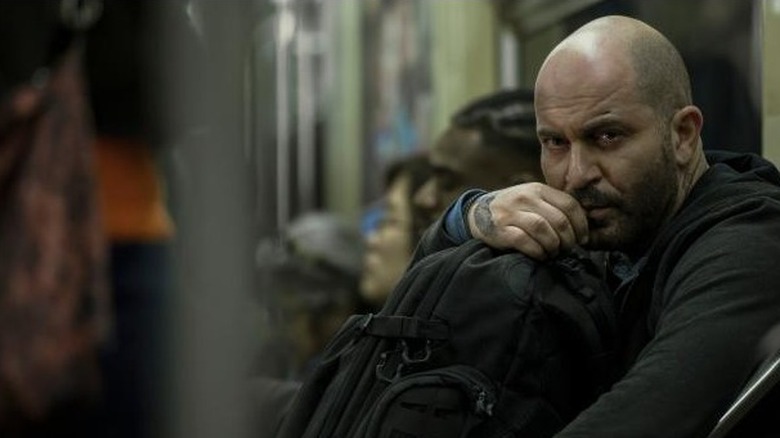 Lior Raz on bus with backpack in lap