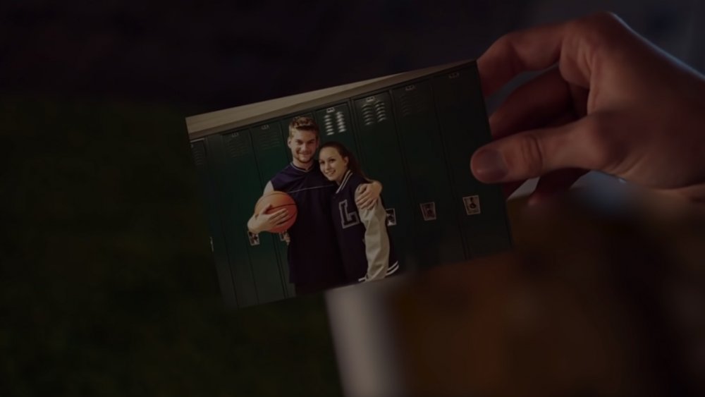 Maika Monroe as Jay, holding a photo of Jake Weary as Hugh and Bailey Spry as Annie in "It Follows"