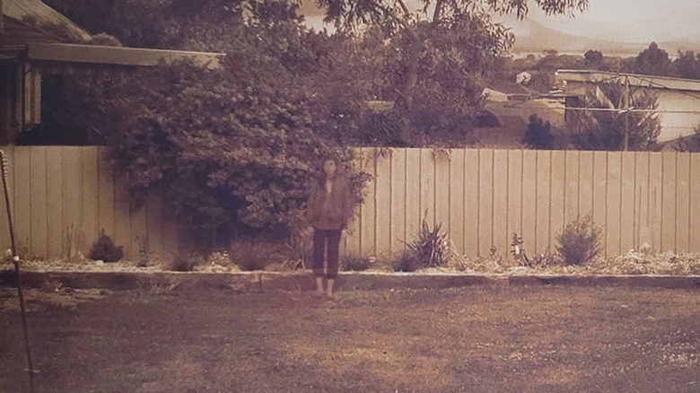 Alice Palmer standing alone in backyard