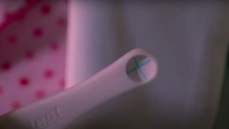 Lois holding up positive pregnancy test