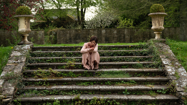 Jessie Buckley sitting on steps 