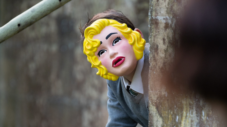 Rory Kinnear in a rubber doll mask 