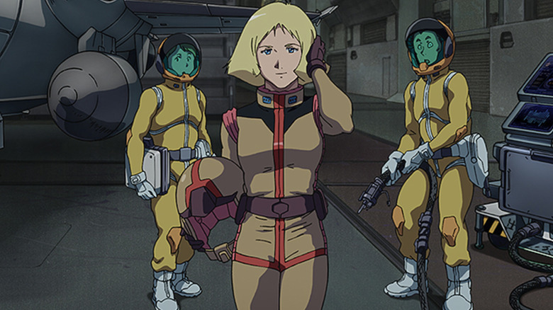 Sayla takes off her helmet with two fellow soldiers