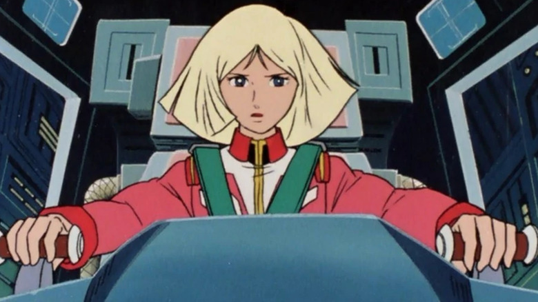 Sayla sits in a cockpit