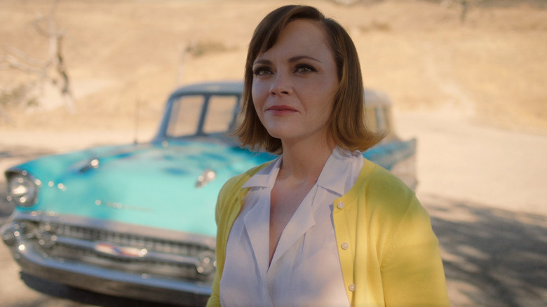 Laura stands in front of her car