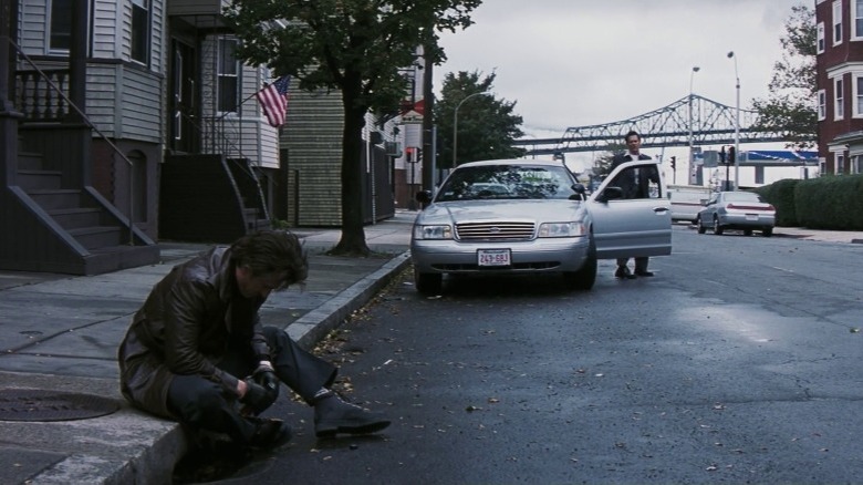 Sean looks at Jimmy sitting on sidewalk