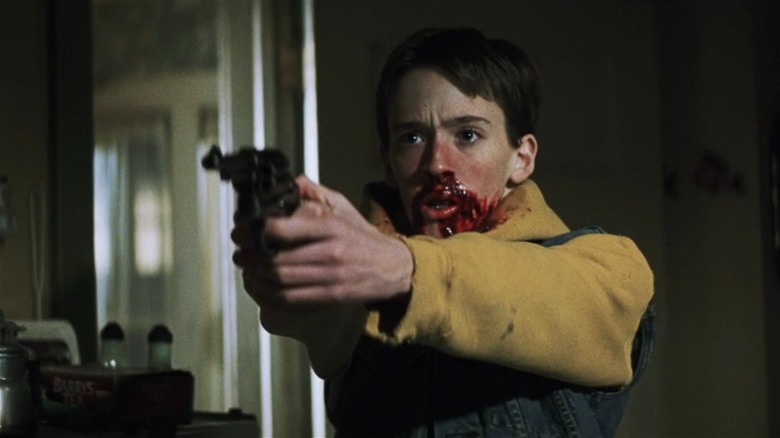 John pointing gun with bloody face