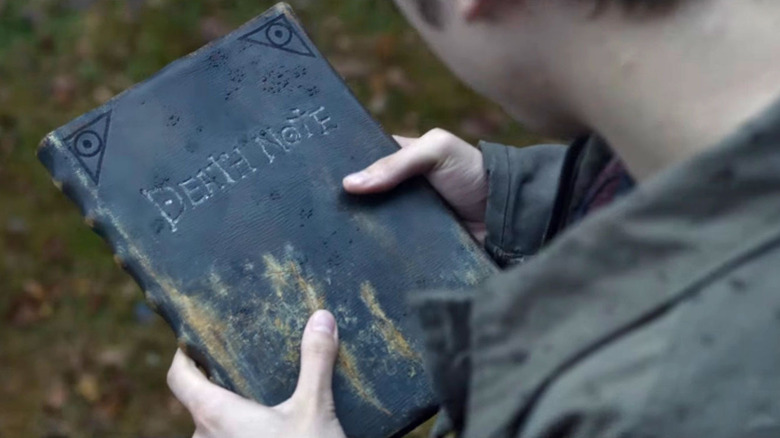 Light holding the "Death Note" notebook 