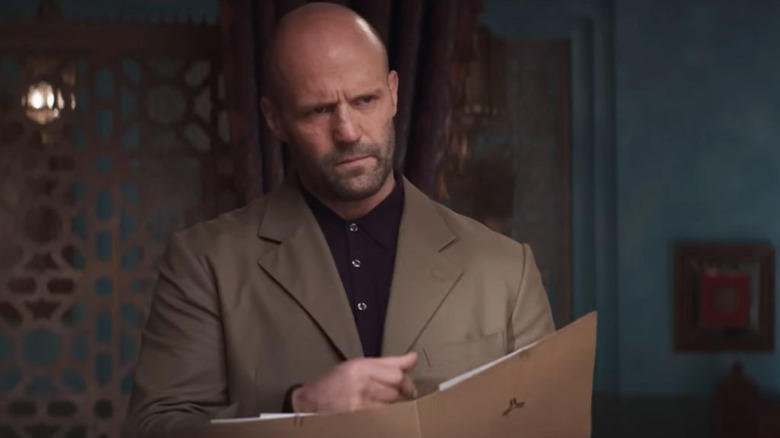 Jason Statham looking over a file