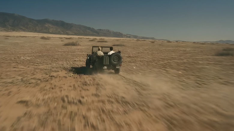 A jeep drives through the desert