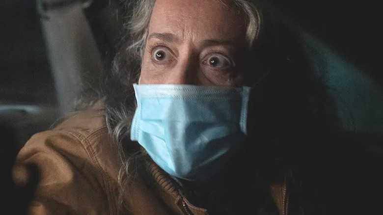 Pamela, eyes wide, wearing a face mask