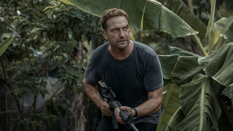 Brodie carries rifle through jungle