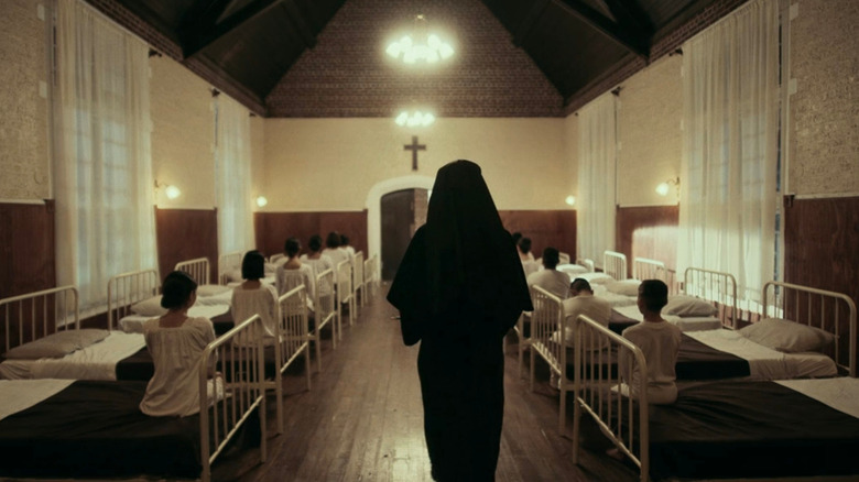 Nun walking between kids beds 