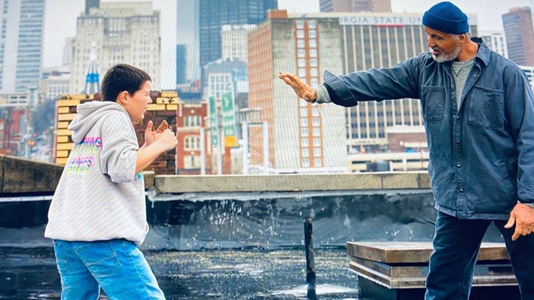 Sam and Joe stand on a rooftop, in a sparring lesson