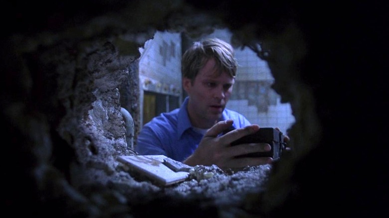 Dr. Gordon finding secret box in hole in wall