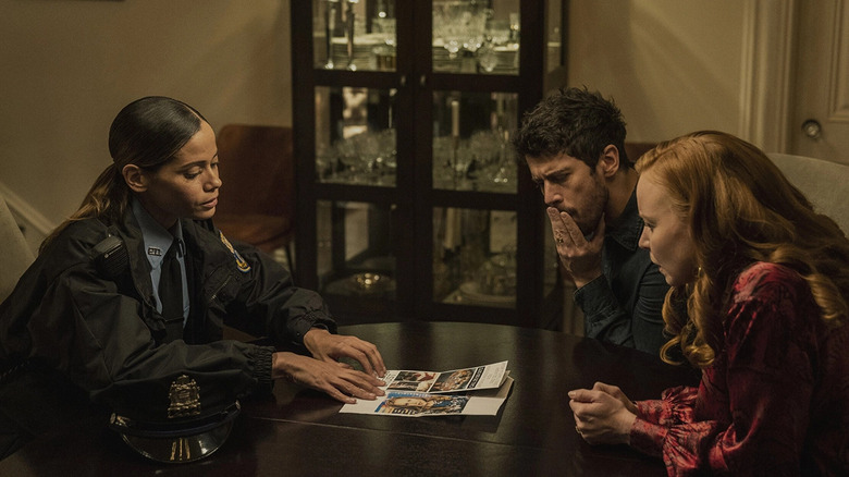 Officer Reyes showing paper to Sean and Dorothy