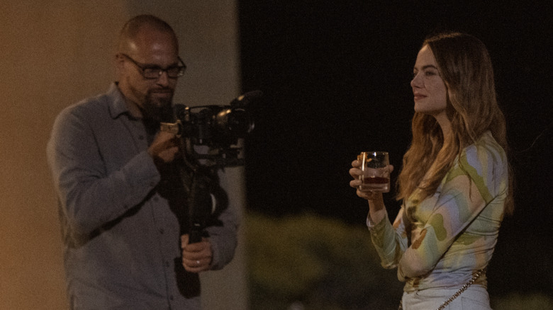 Whitney holding a drink while being filmed