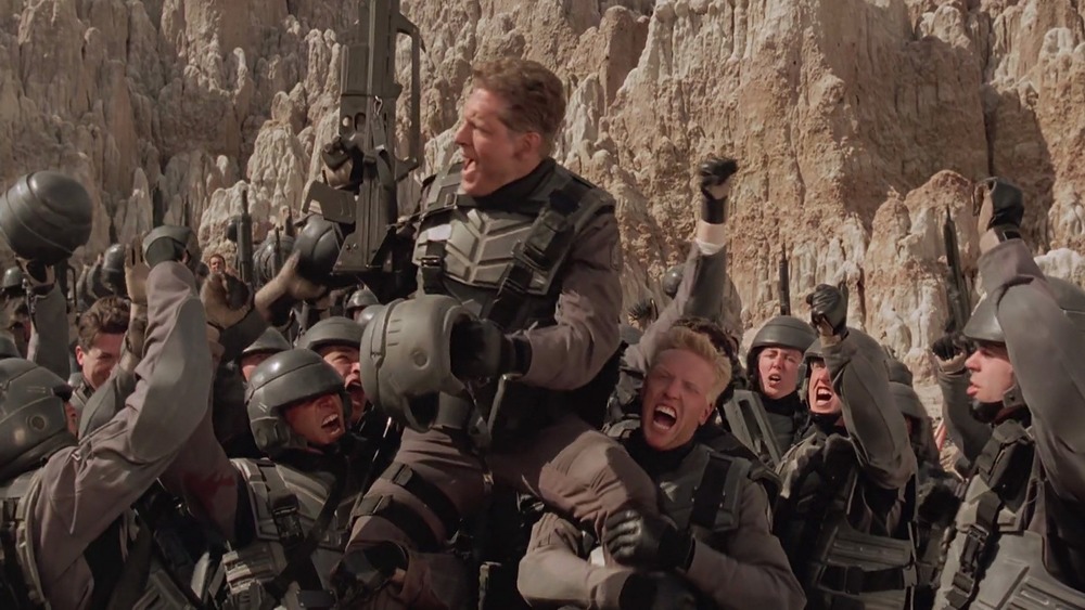 Clancy Brown surrounded by soldiers