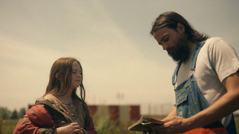 Haley hands a  book to Tyler Leander