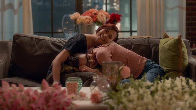 Alex and Kara hugging on couch