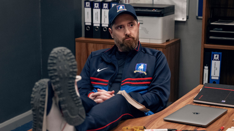 Coach Beard with legs resting on table