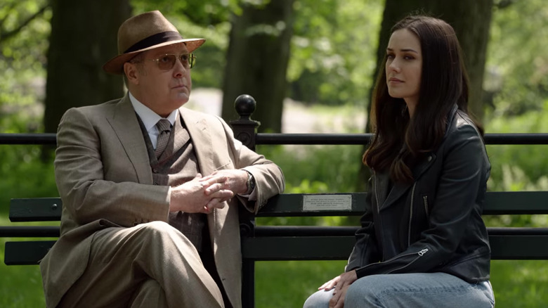 Megan Boone and James Spader sitting on park bench