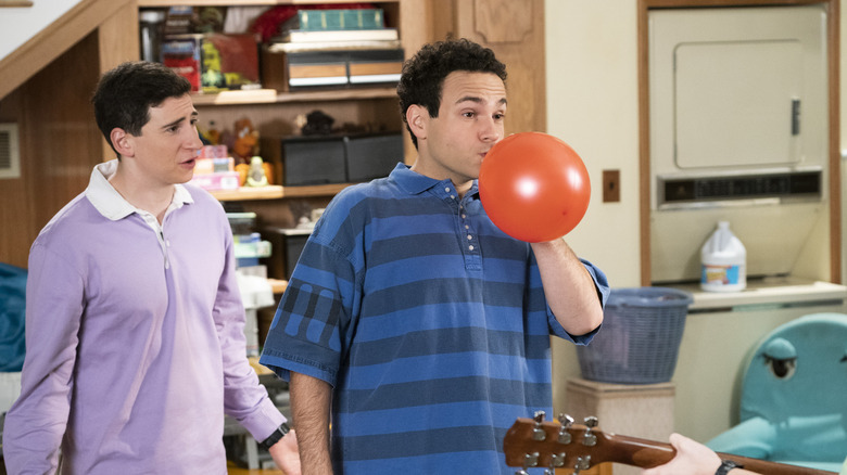 Barry blowing up ballon next to Geoff