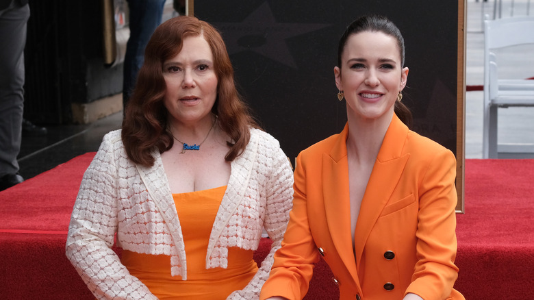 Alex Borstein and Rachel Brosnahan wearing orange on red carpet