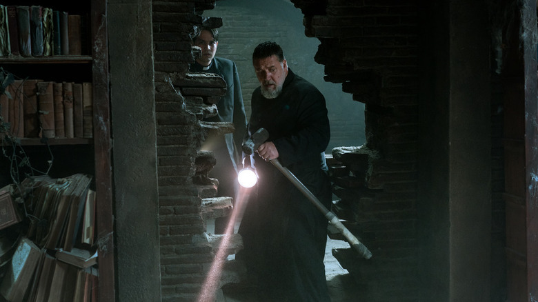 Father Amorth holding a flashlight and mallet