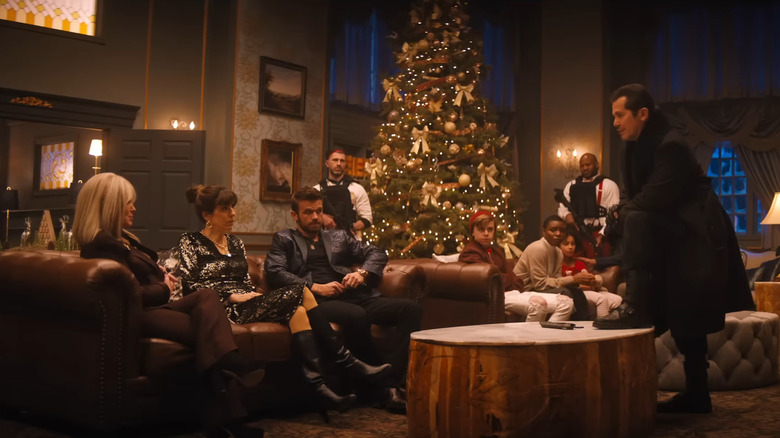 Violent Night cast sitting in living room on Christmas Eve