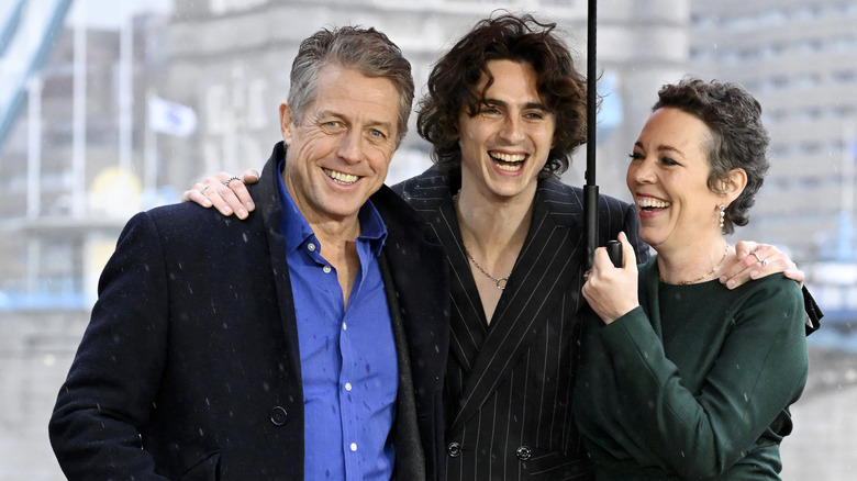 Hugh Grant, Timothée Chalamet, and Olivia Colman smiling