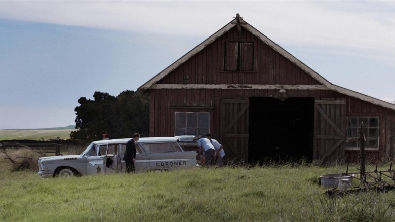 Coroner vehicle parked outside barn