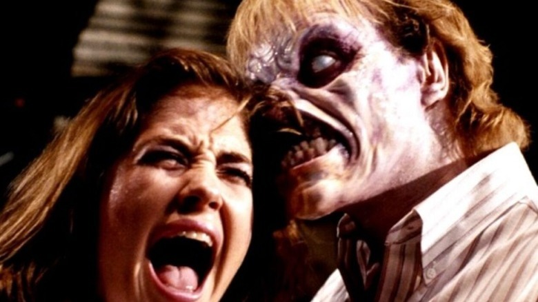 A zombie takes a bite of a screaming woman's hair