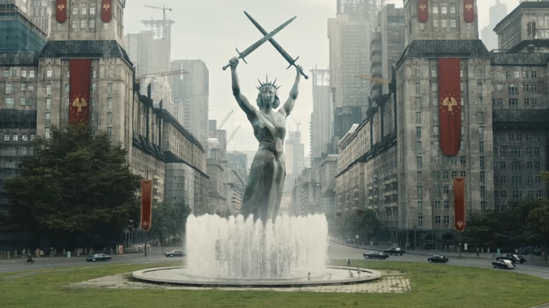 A fountain of a person holding two swords in the air