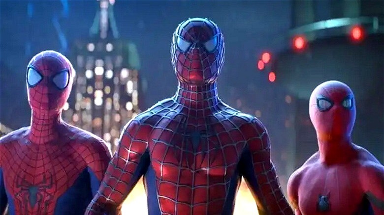 All three Spider-Men next to each other in front of tall buildings