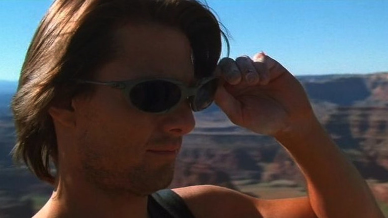 Ethan Hunt removes sunglasses from his face