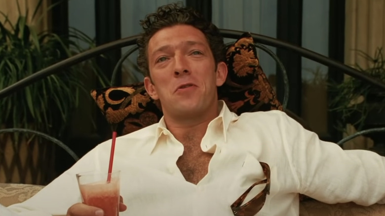 Vincent Cassel smiling and drinking juice