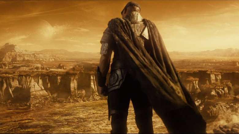 Vin Diesel in Riddick wearing cape on desolate planet