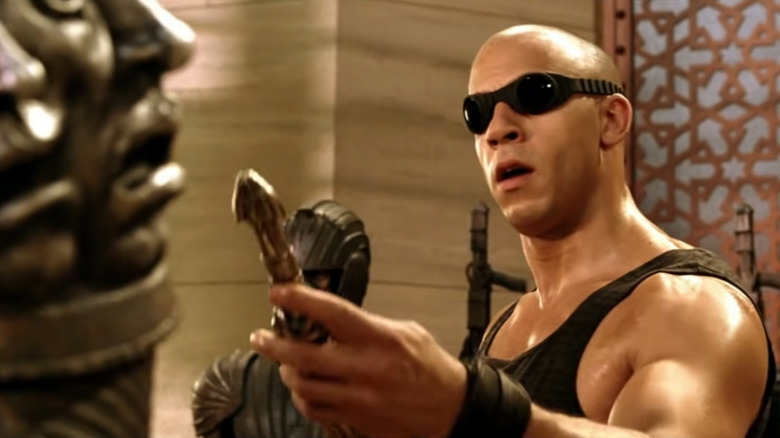 Vin Diesel Chronicles of Riddick holding knife black tank top goggles