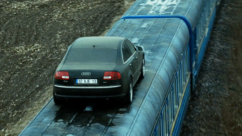 A car drives across the top of a train