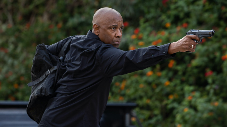 Denzel Washington aiming a gun as Robert McCall