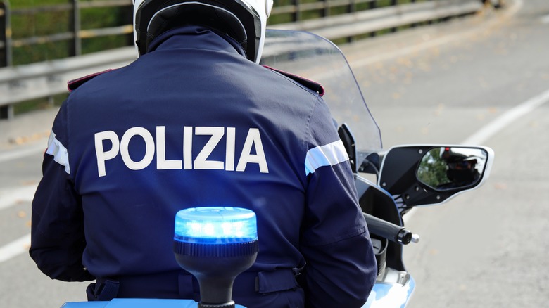 The back of an Italian Police officer riding a motorbike 