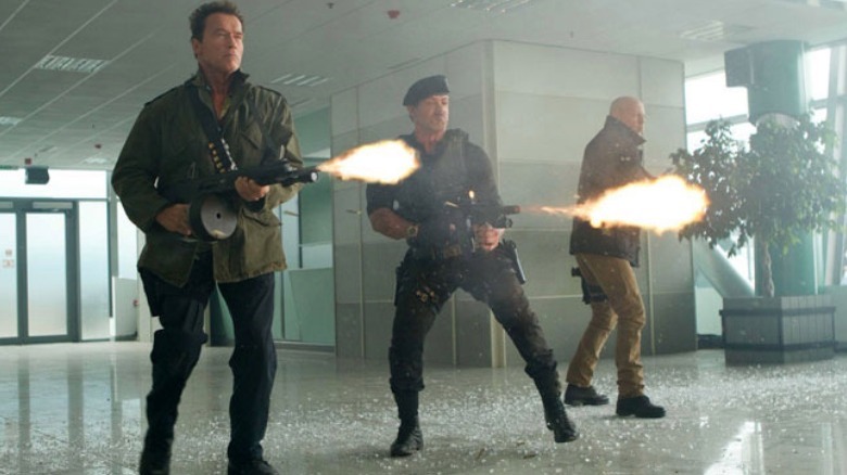 Arnold Schwarzenegger, Sylvester Stallone, and Bruce Willis fire guns