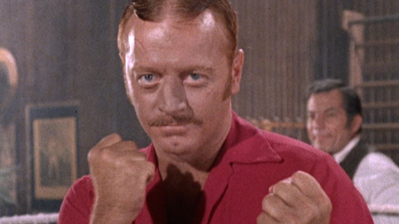 A mustachioed Red West raises his fists